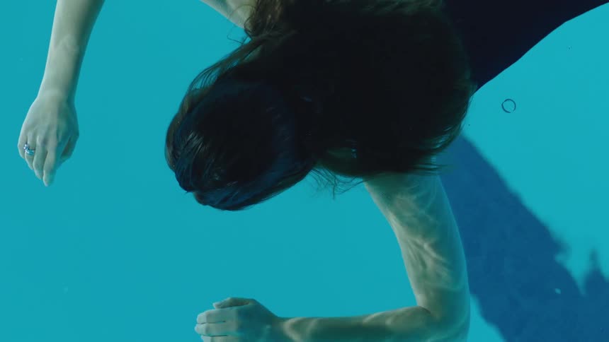 A woman floats face down in a swimming pool