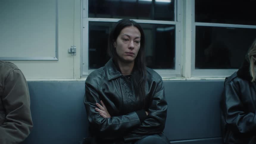 A woman looks sad while sitting in a subway car
