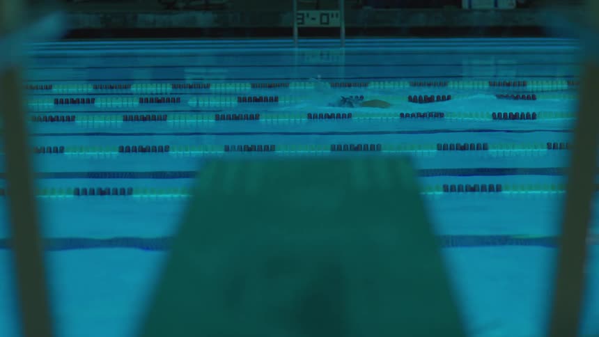 Legs of a person jumping towards a pool with water dividers