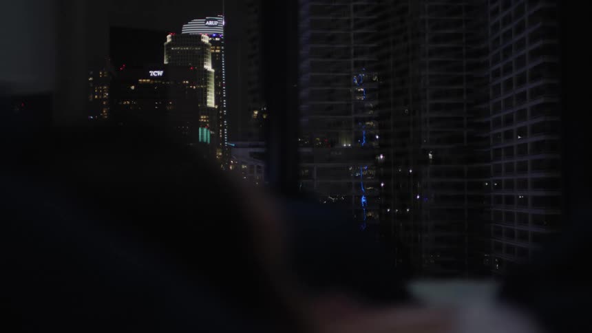 Some buildings in a city at night and some lights from the buildings on