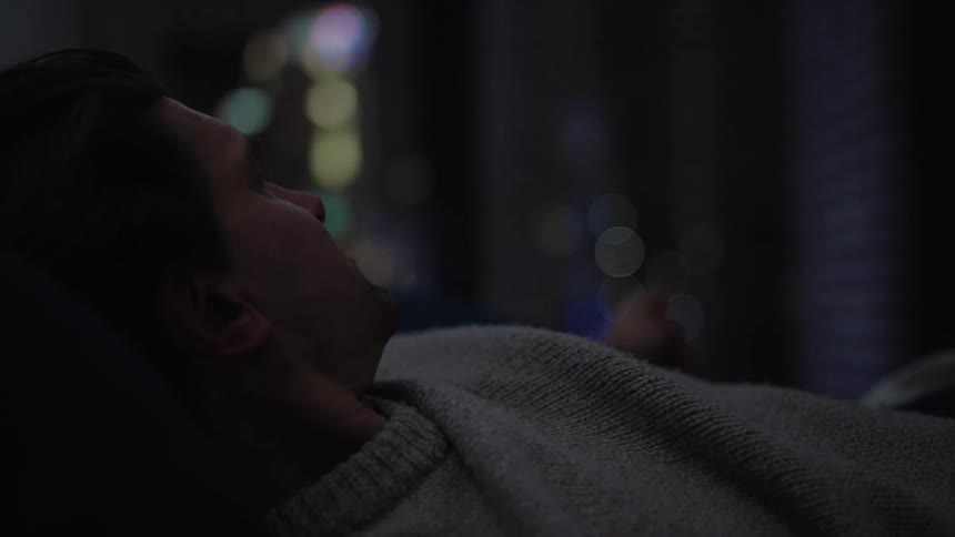A man yawning and rubbing his face as he wakes up