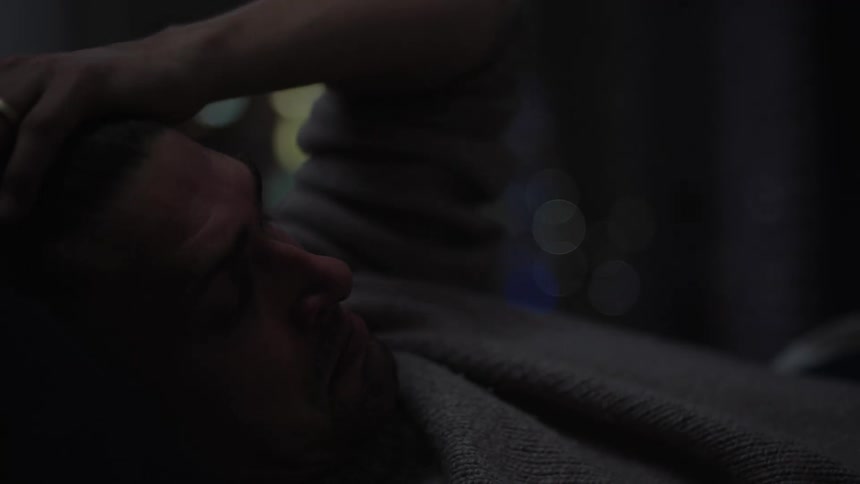 Close up of the face of a tired man rubbing his face with his hands