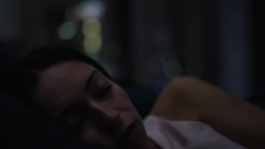 A young woman sleeps and rests in a bed