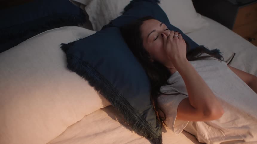 Woman lying in bed breathing deeply and sleeping