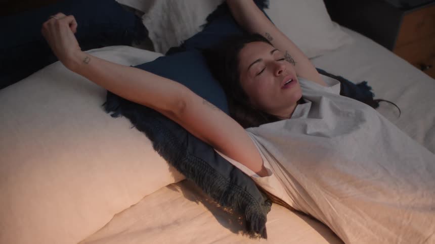 A woman wakes up and turns in bed