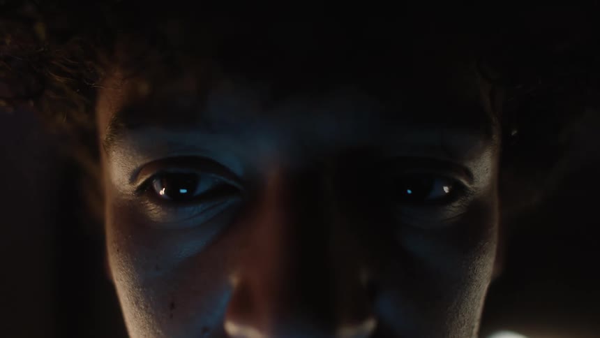 Portrait of a young man staring straight ahead with sparkles in his eyes