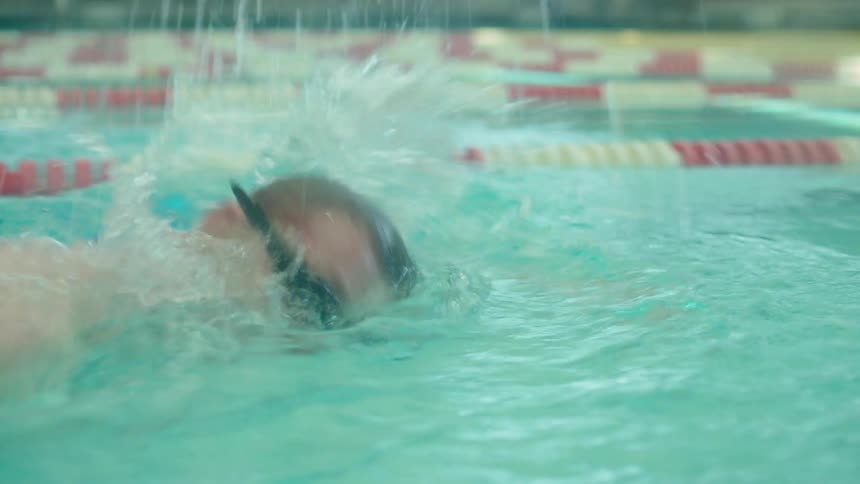 A white man swims in a swimming pool