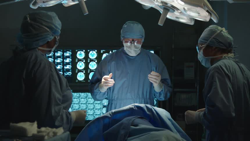 Medical team with surgeon and nurses in protective clothing inside a surgical room preparing