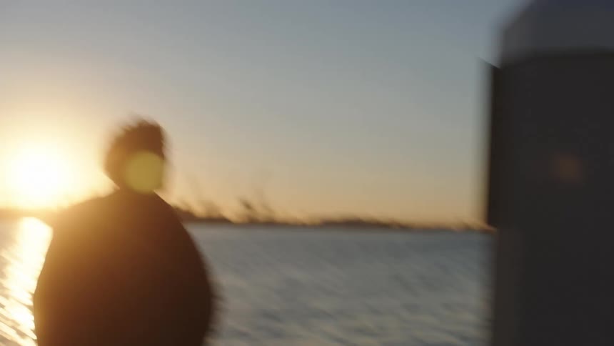 A man runs down a wooden pier on a coast