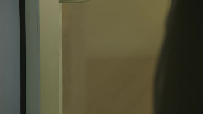 A man unlocks a door with a key ring