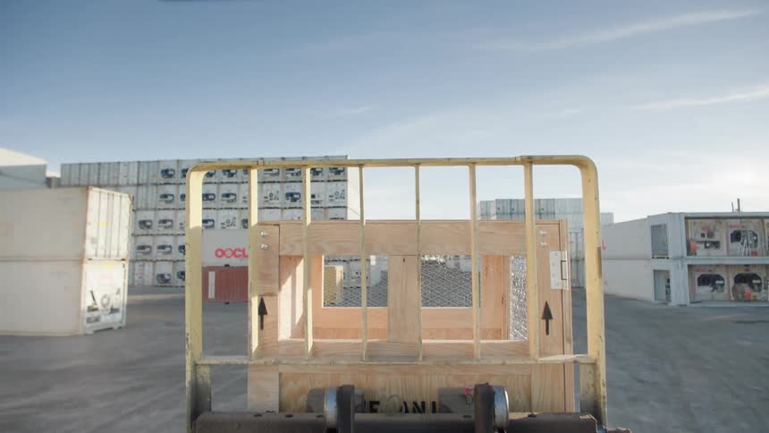 A forklift driving in between large shipping containers
