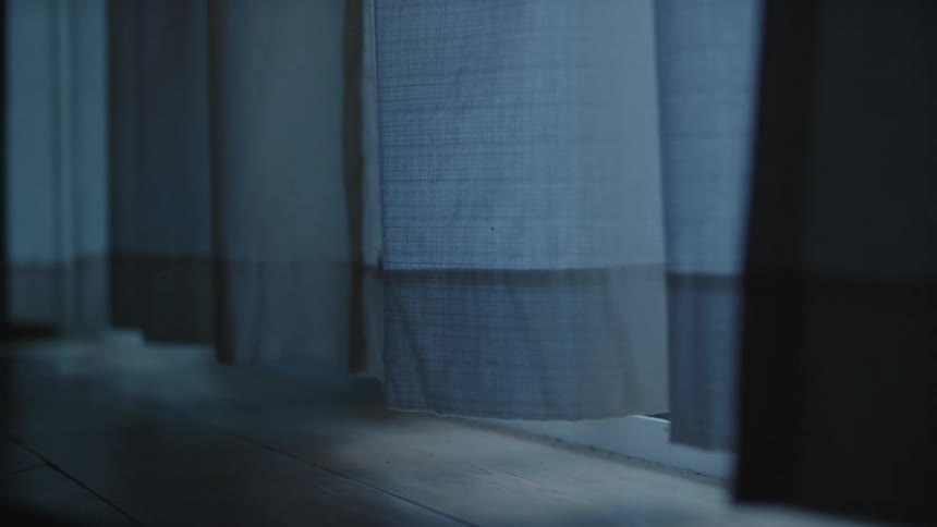 Blue curtains floating in the wind in a room