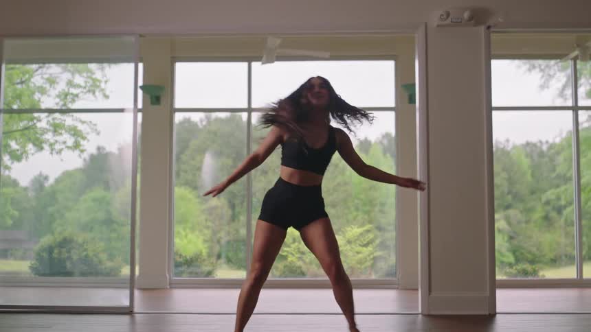 A woman jumps as she dances in the hall