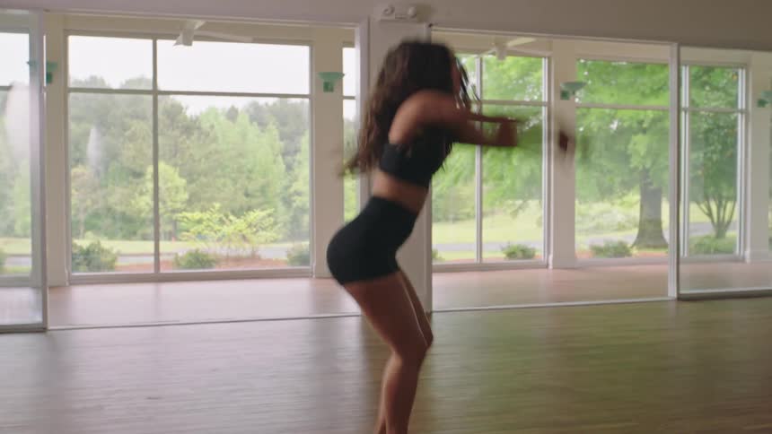 A young woman dances in an empty room