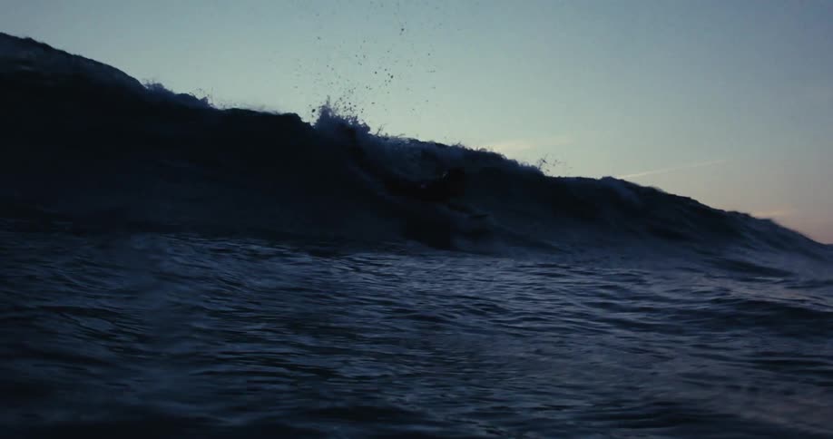 A man is riding a wave on his surfboard