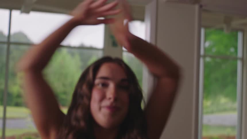 Portrait of a woman raising her arms in a training and dancing movement