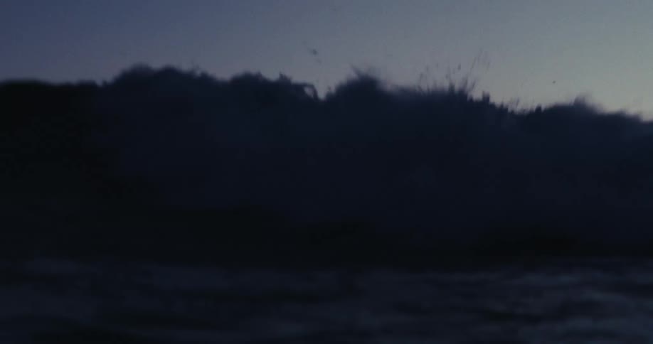 A sea wave coming straight on a dark morning