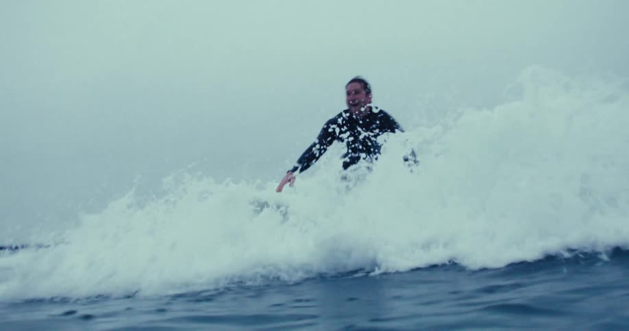 A man in a swimsuit is surfing an ocean wave