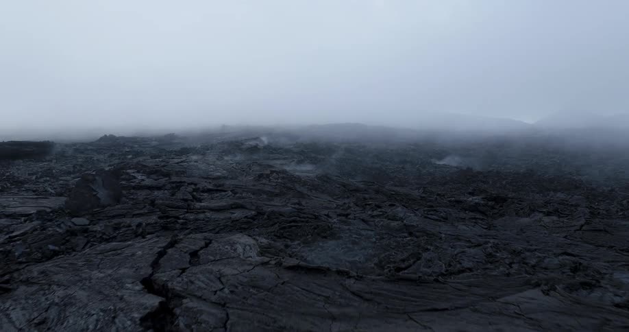 A vast lava field with smoke rising from fissures