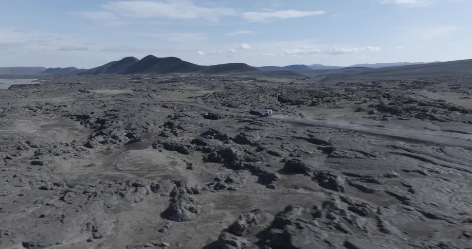 An off road car driving on a sandy street in a desert region