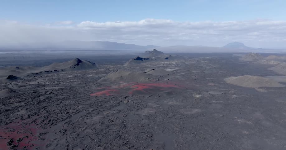 A vast lava field with mountains in the distance