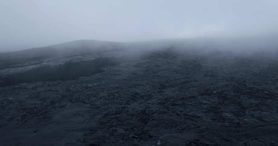 Aerial view of smoke over a mountainous volcanic terrain