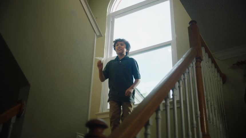 Little boy climbing the ladder and throwing a plane made of paper