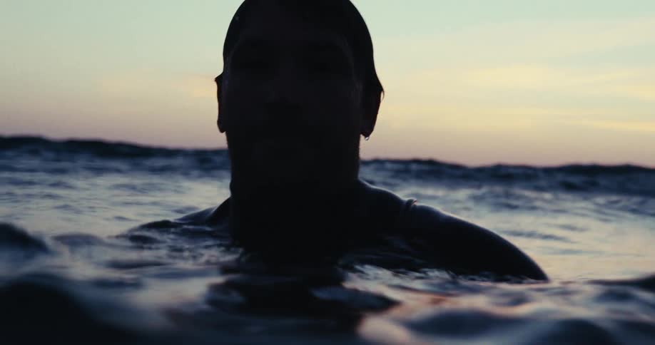 Silhouette of a mans face inside the sea in a morning sky