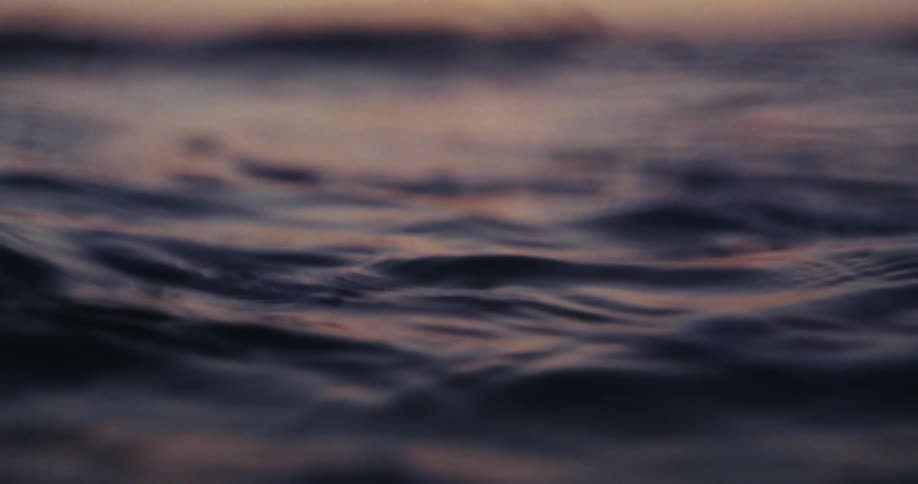 Oceanic waters with calm waves on a morning with a purple sky