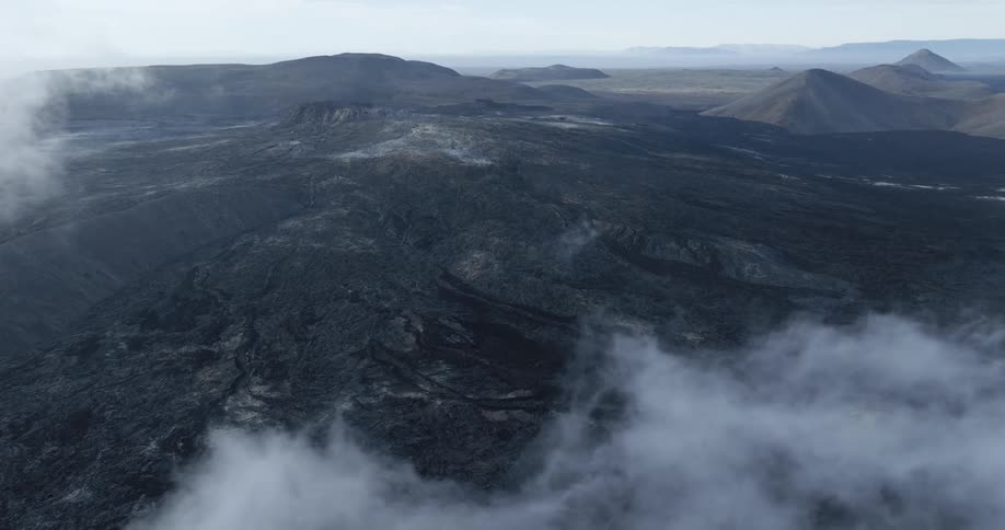 Aerial panorama of craters with erosions and mountains around in a morning