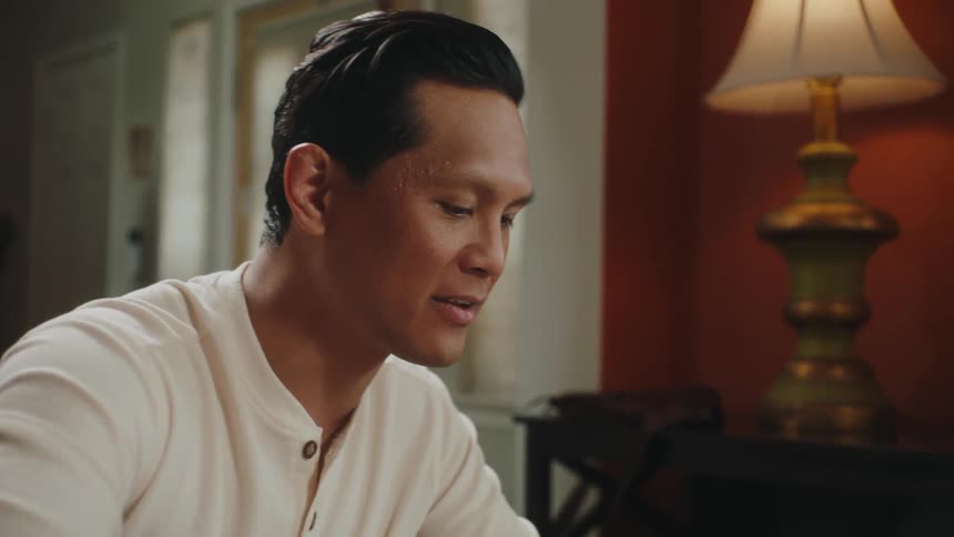 Portrait of a man sitting at the table and talking to a person next to him
