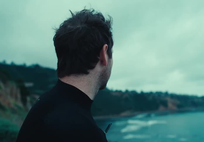A man in a wetsuit gazing at the sea