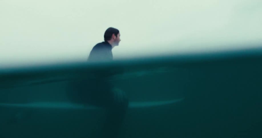 A surfer in the sea sitting on his board waiting for waves