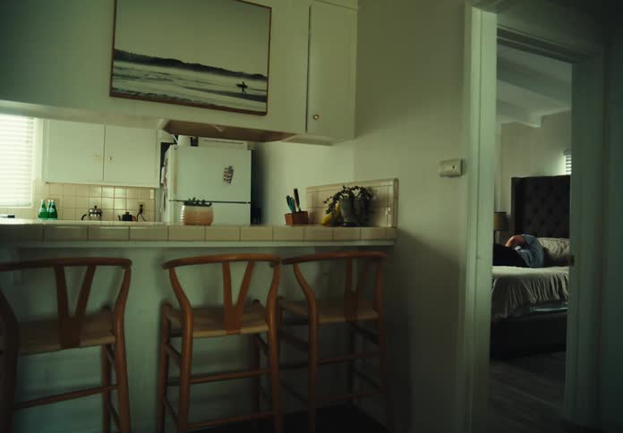 A woman sleeps in a bed near a kitchen
