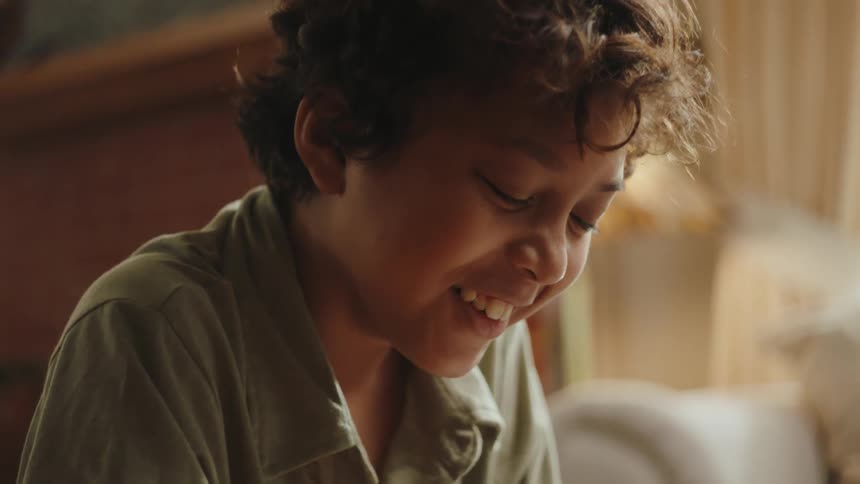 Portrait of a smiling little boy while standing in the room indoors