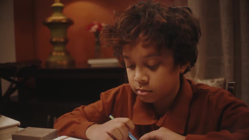 Father helping his son with homework in the living room