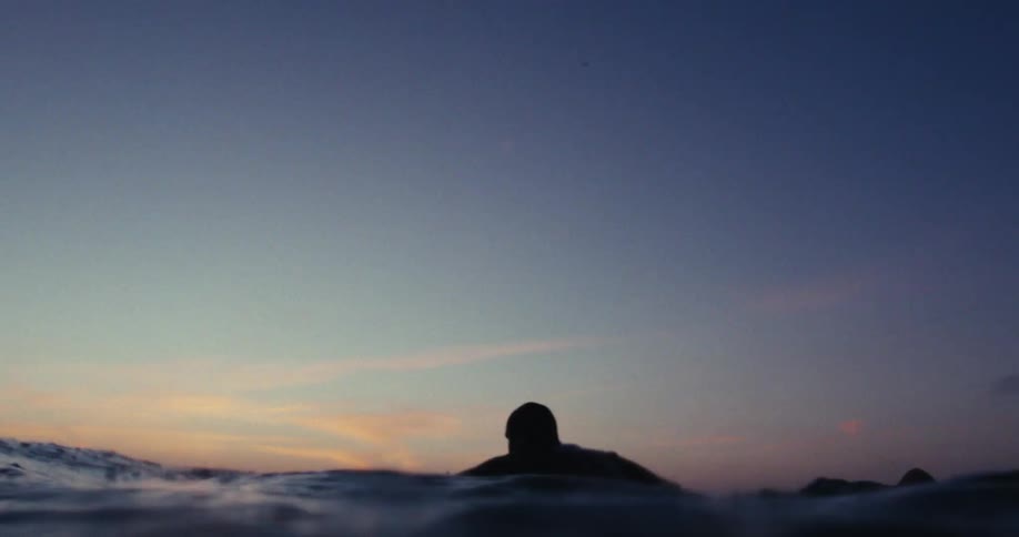 A man is surfing at sunrise