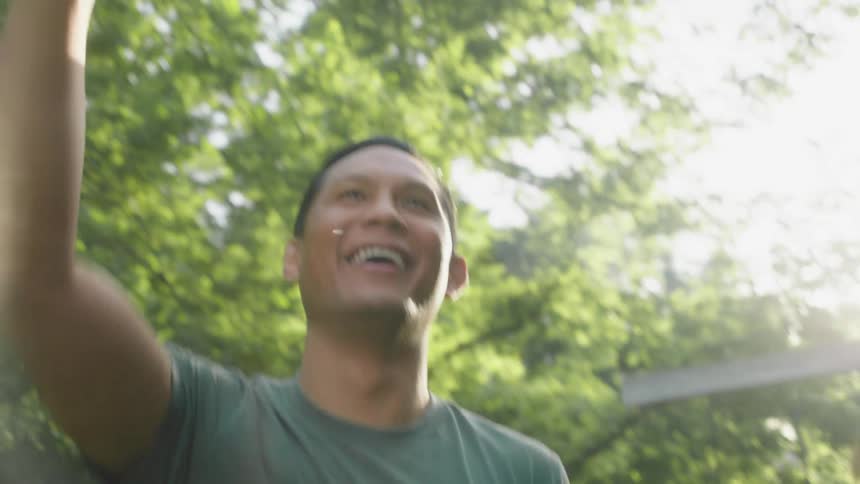 Portrait of a man in an outdoor setting throwing a cardboard plane
