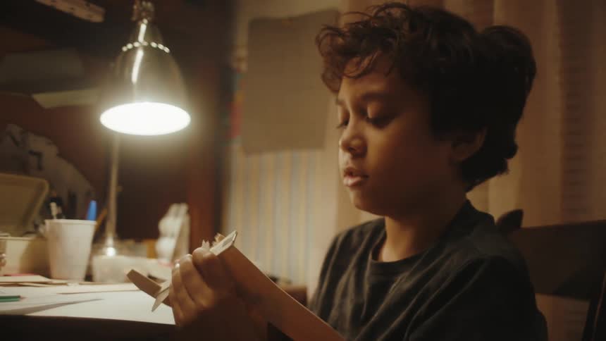A boy breaks the wing of a paper plane by accident