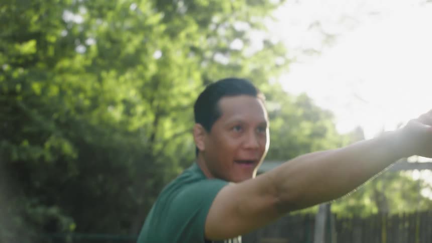 Portrait of a man in an outdoor setting throwing a cardboard plane into the air