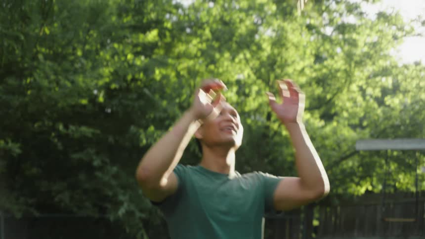 A man playing with a toy plane in the backyard