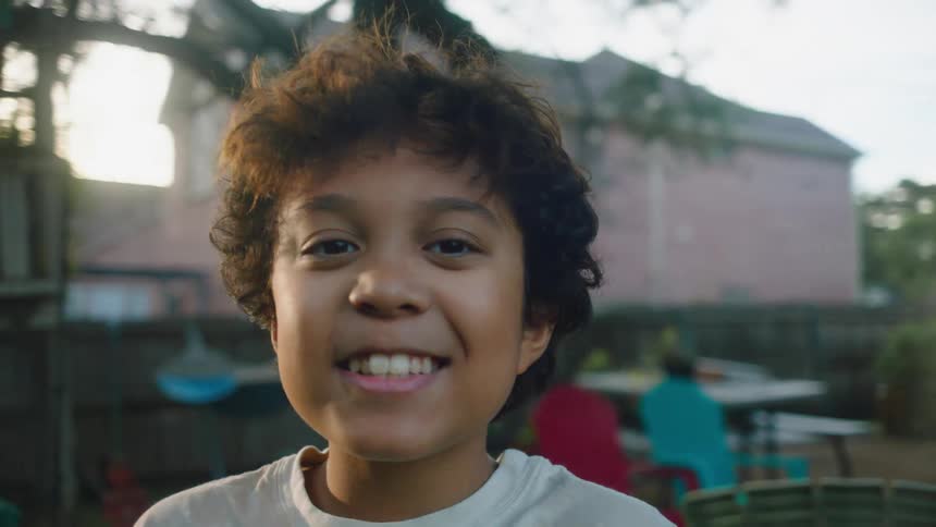 Portrait of a smiling boy while standing in the backyard