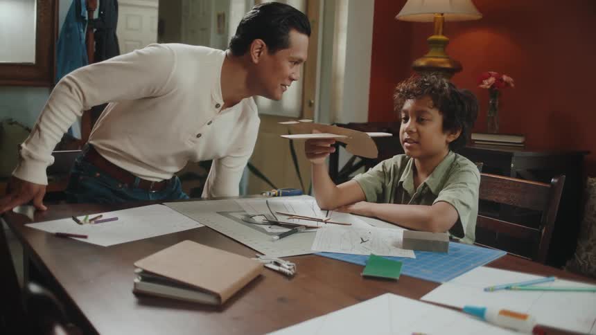 A father talks to his son about a toy plane