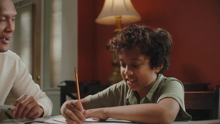 Father and son doing homework in the living room
