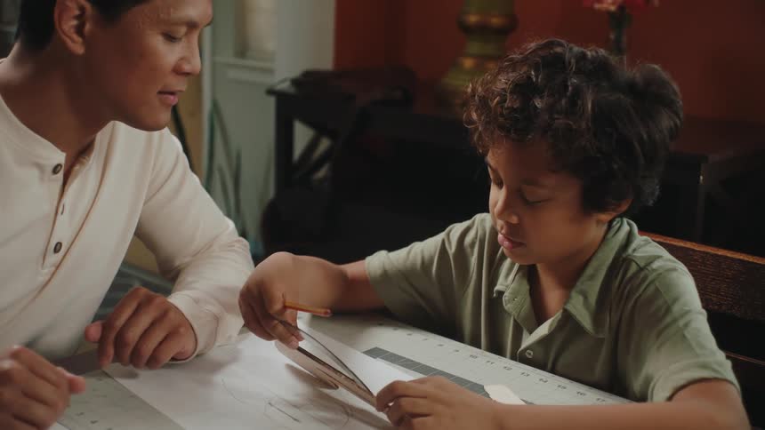 Father and son doing homework in the living room