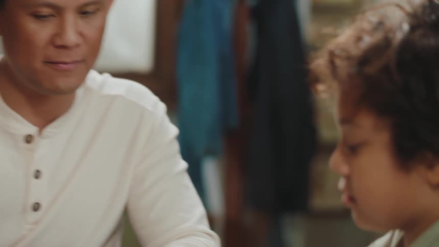 Father helps his son with his math homework