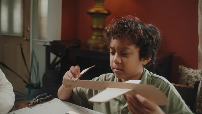 Portrait of father and son building a cardboard airplane