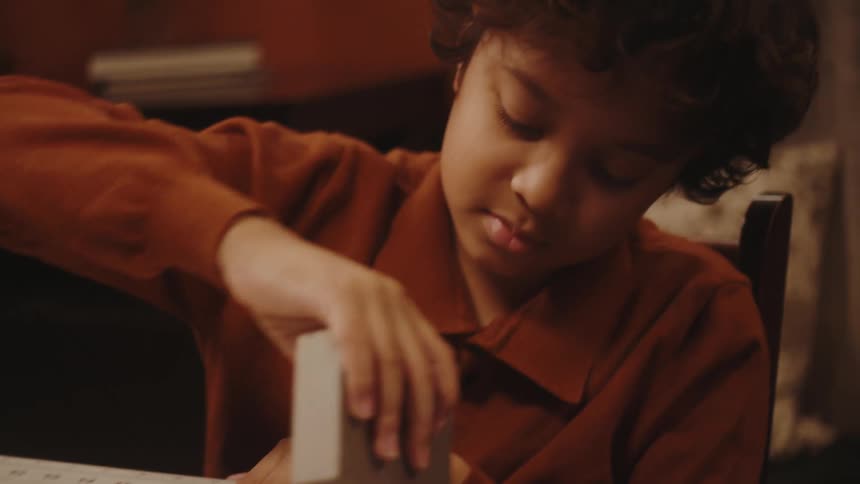 A boy crafting a balsa wood toy plane at home