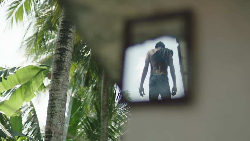 A black man stands outside in a forest