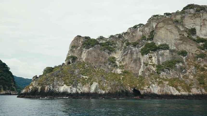 Blue sea at the edge of a rocky coast on a cloudy day